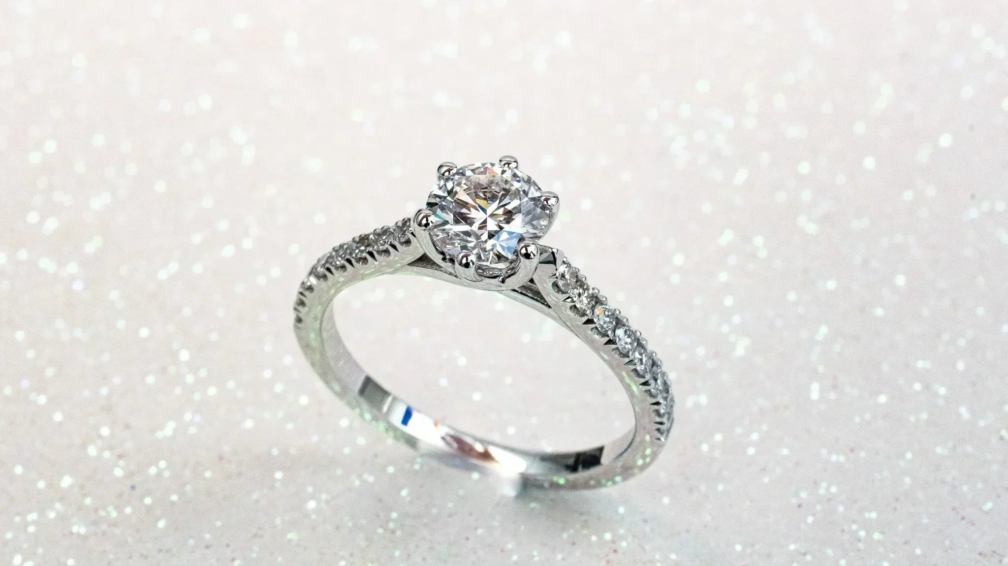 Elegant lab grown diamond engagement ring on a sparkling background, showcasing its brilliance and craftsmanship.