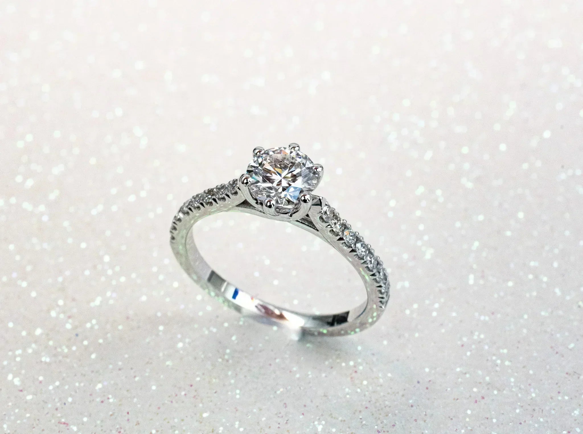 Elegant lab grown diamond engagement ring on a sparkling background, showcasing its brilliance and craftsmanship.